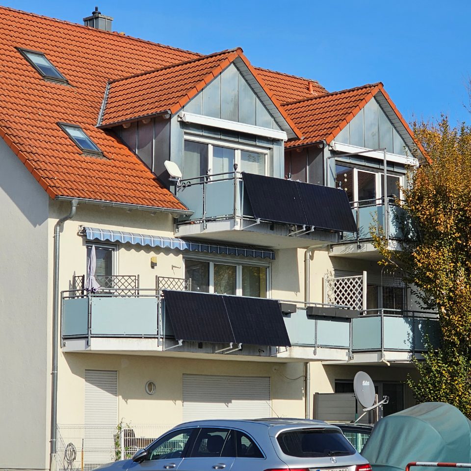 A plug-in solar panel fixed to the railing of a balcony